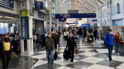 People travelling wear facemasks as they walk through Chicago OHare International airport (ORD)on October 5, 2020 in Chicago, Illinois. (Photo by Daniel SLIM / AFP) (Photo by DANIEL SLIM/AFP via Getty Images)